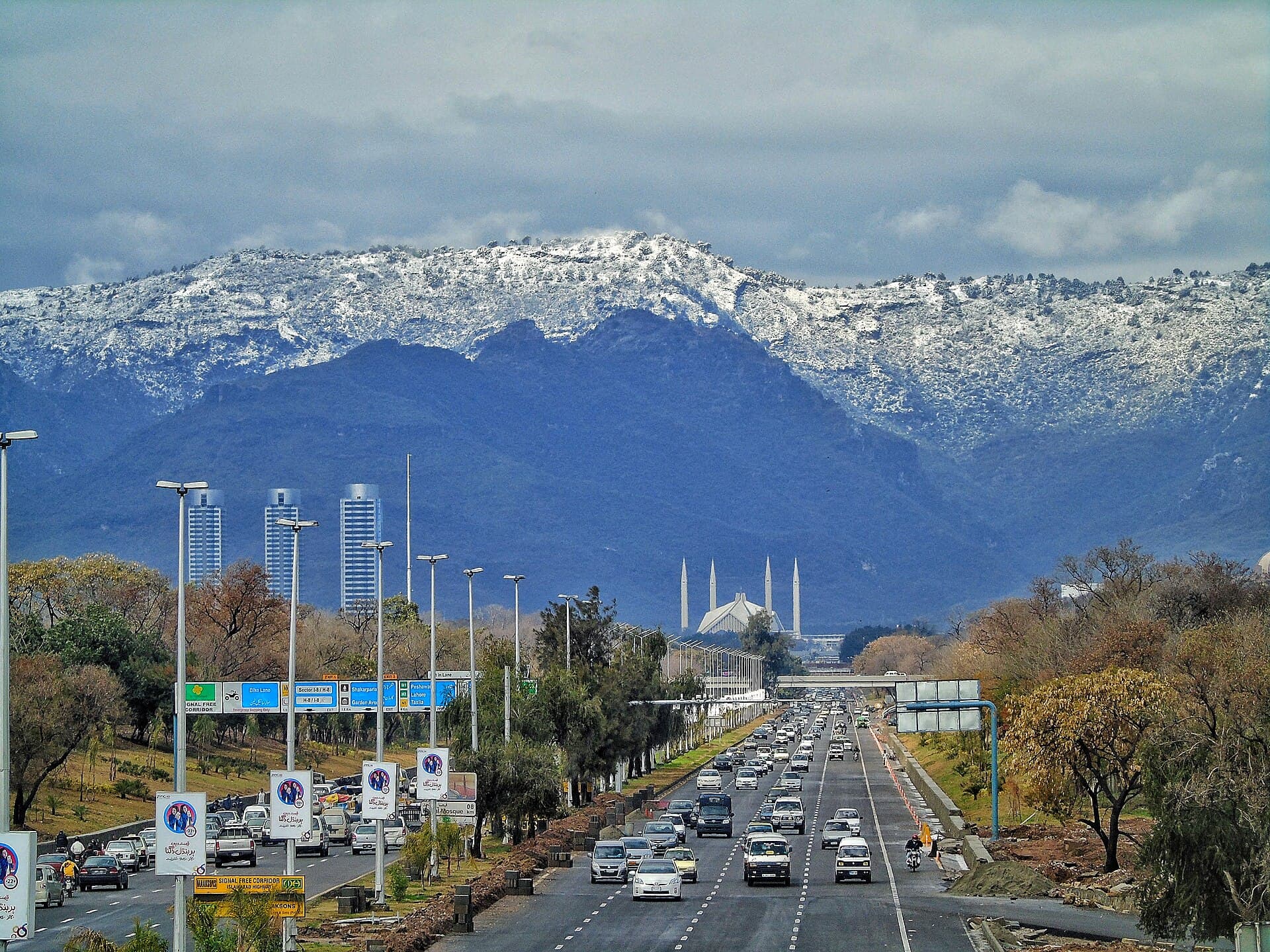Islamabad Highway with the snow-capped Margalla Hills and Faisal Mosque